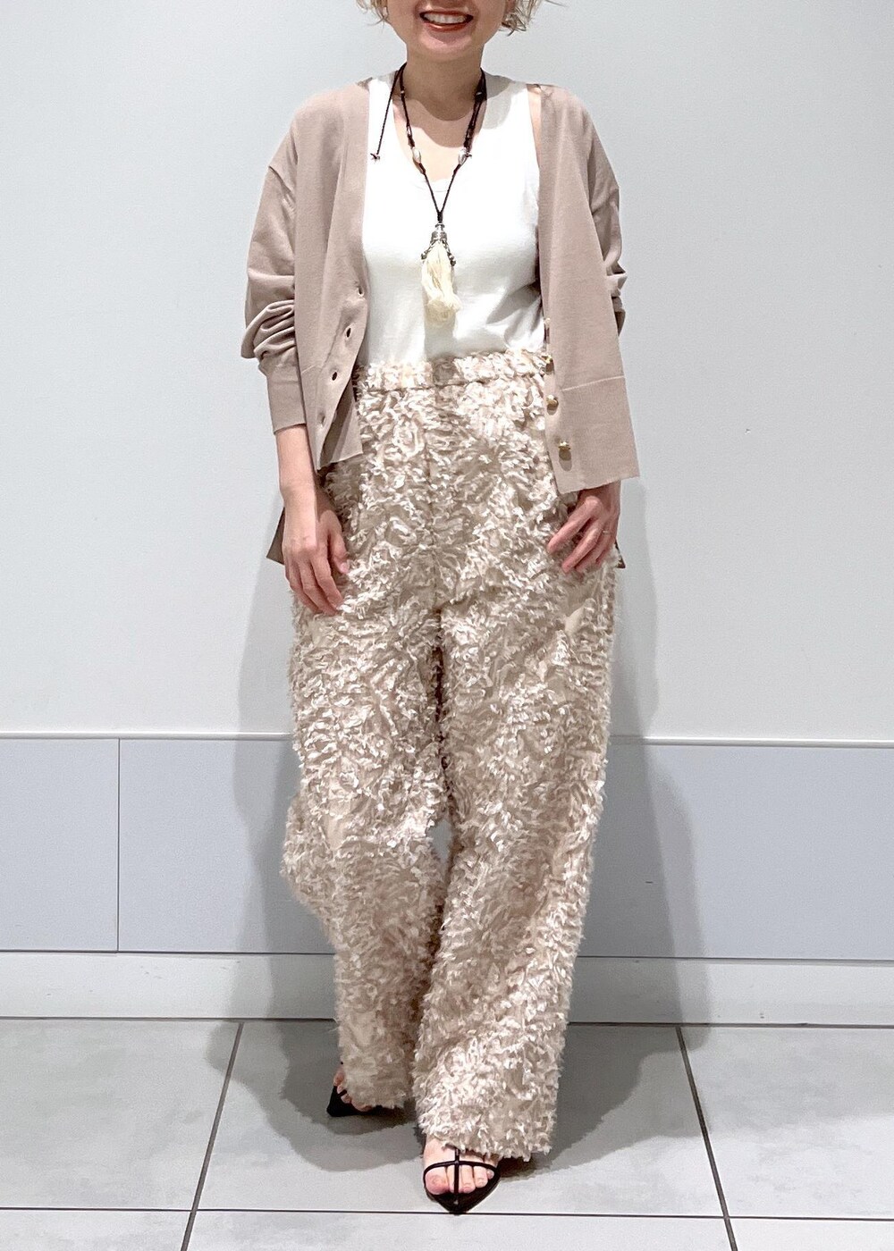 ベージュ系のカーディガン/ボレロ、ブラック系のサンダル、ベージュ系のその他パンツを着用したレディースの春コーディネートの4枚目の写真