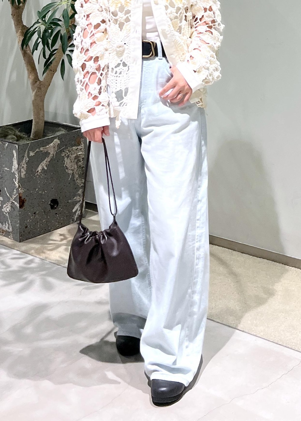 ブルー系のデニムパンツ、ブラウン系のハンドバッグを着用したレディースの夏コーディネートの9枚目の写真