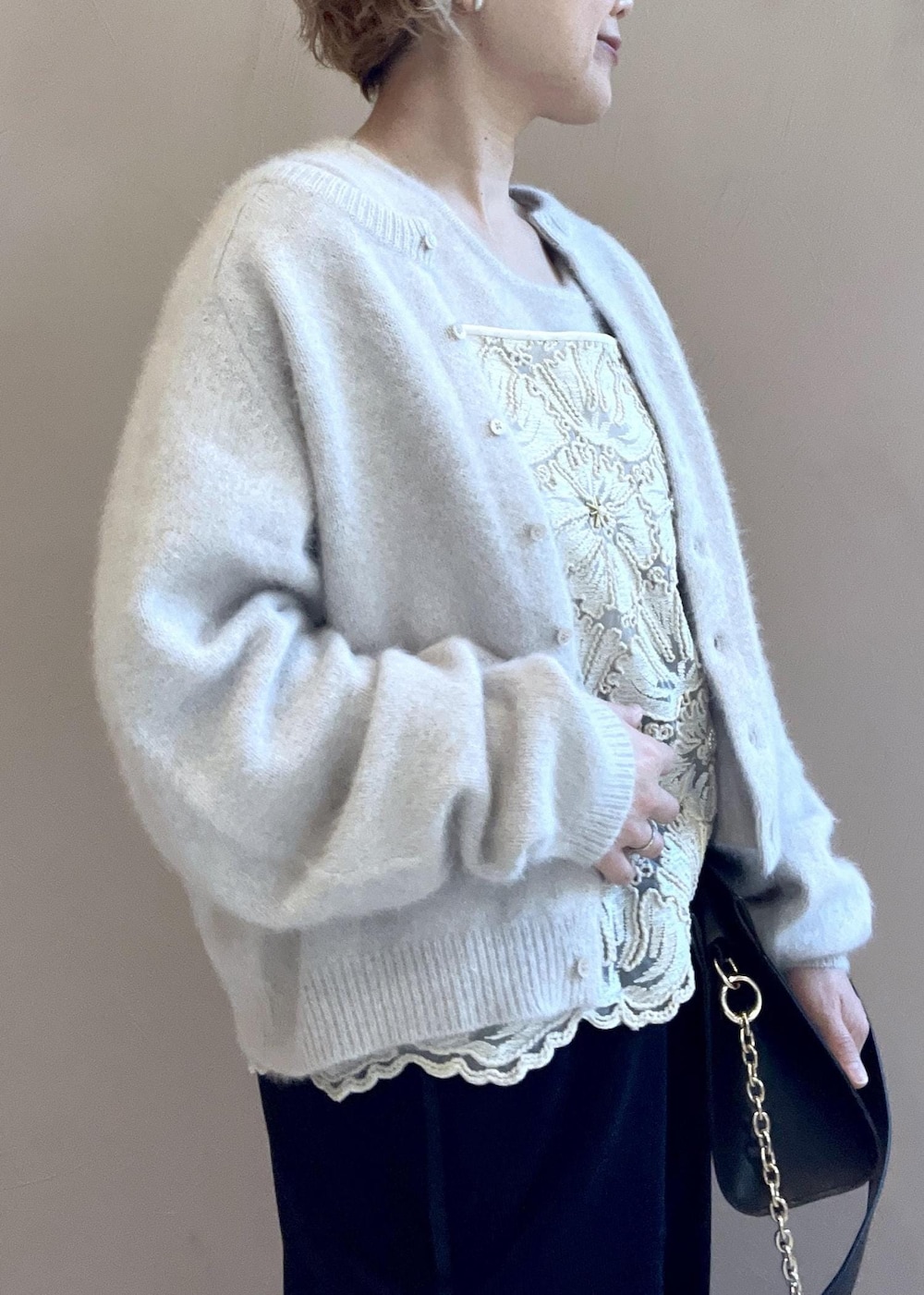 グレー系のタンクトップ、グレー系のカーディガン/ボレロ、ブラック系のショルダーバッグを着用したレディースの冬コーディネートの9枚目の写真