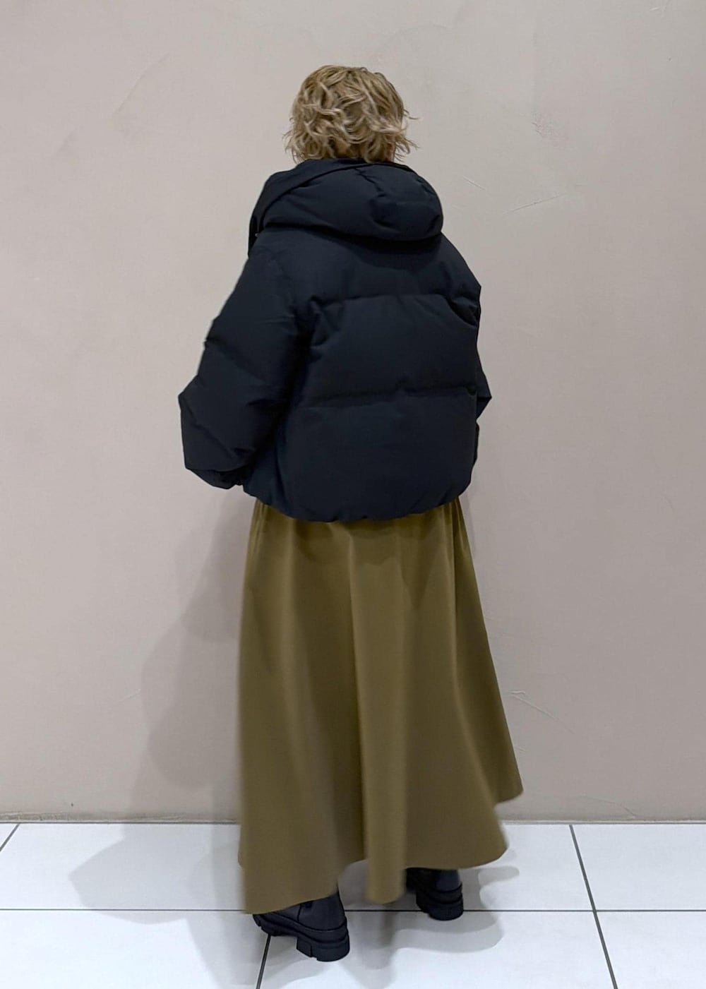 ブラウン系のスカート、ブラック系のダウンジャケット/コート、グレー系のニット/セーターを着用したレディースの冬コーディネートの5枚目の写真