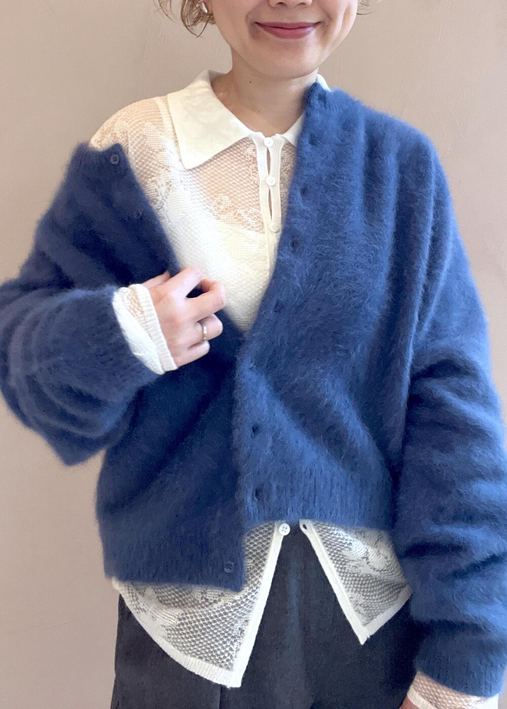 ブラック系のショルダーバッグ、ブルー系のカーディガン/ボレロ、グレー系のスラックスを着用したレディースの冬コーディネートの6枚目の写真