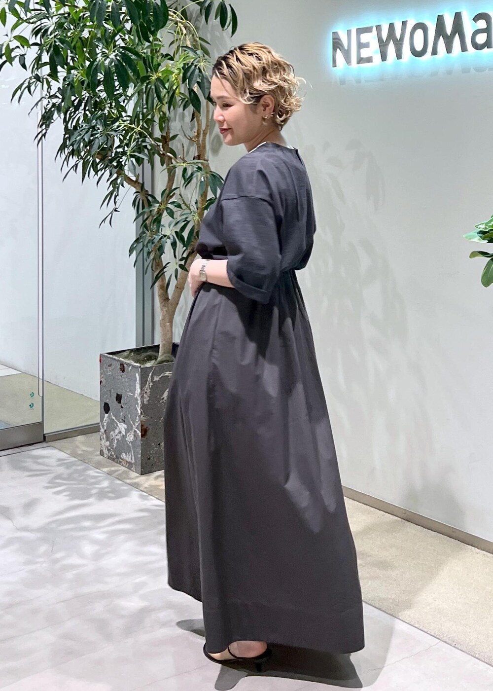 グレー系のスカート、グレー系のTシャツ/カットソー、ホワイト系のサンダルを着用したレディースの春コーディネートの6枚目の写真