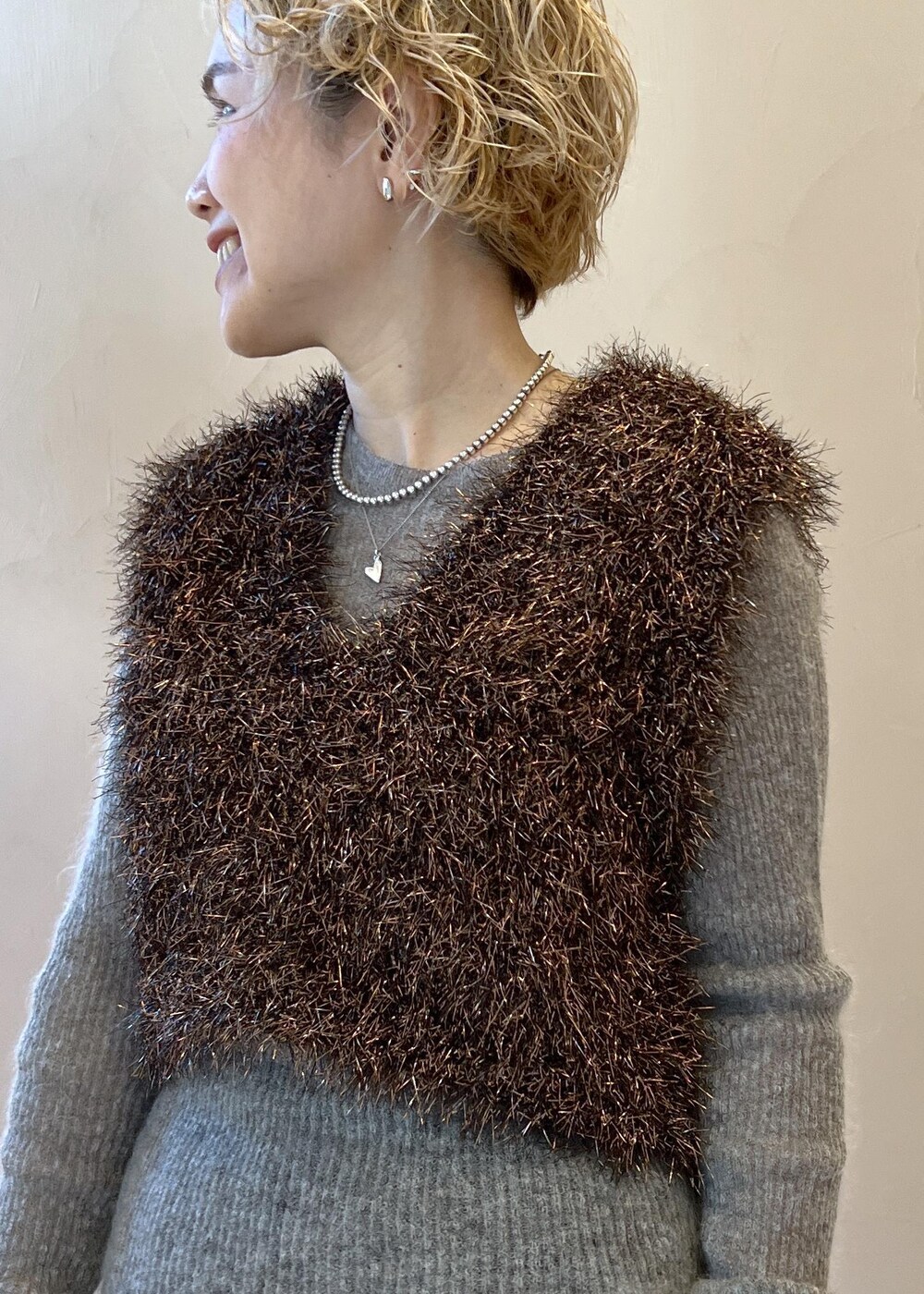 ブラック系のステンカラーコート、グレー系のニット/セーター、ブラック系のその他パンツを着用したレディースの冬コーディネートの5枚目の写真