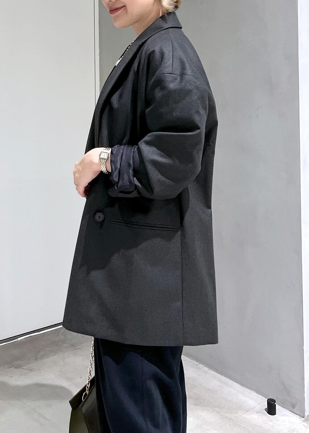 グリーン系のショルダーバッグ、ブラック系のスウェットパンツ、シルバー系のパンプスを着用したレディースの秋コーディネートの5枚目の写真