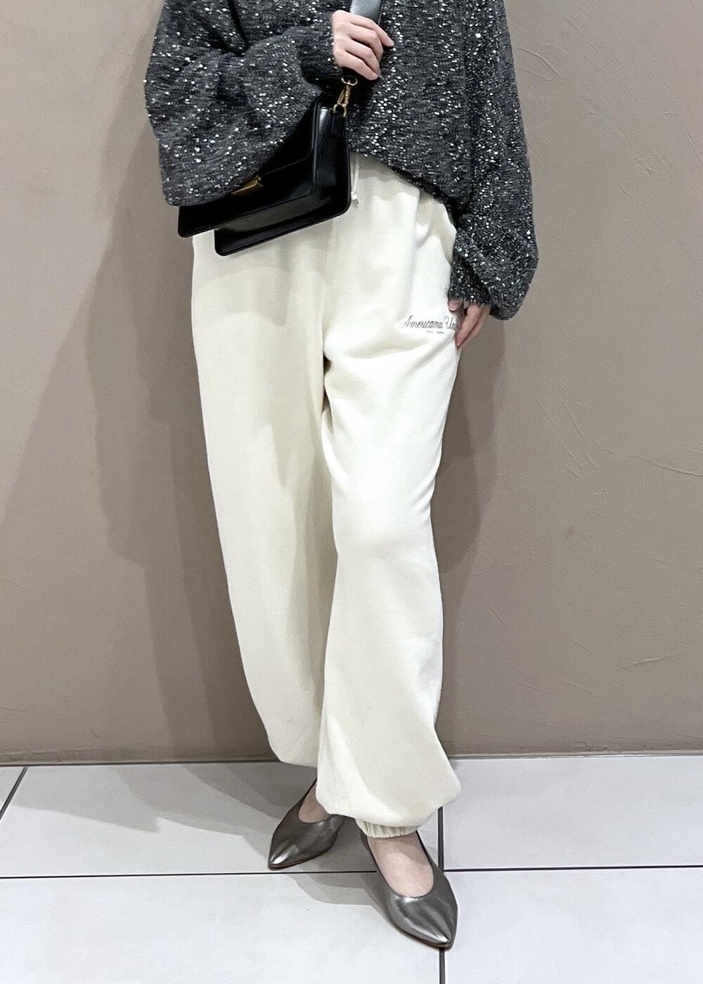 ホワイト系のスウェットパンツ、ブラック系のショルダーバッグ、シルバー系のパンプスを着用したレディースの秋コーディネートの8枚目の写真