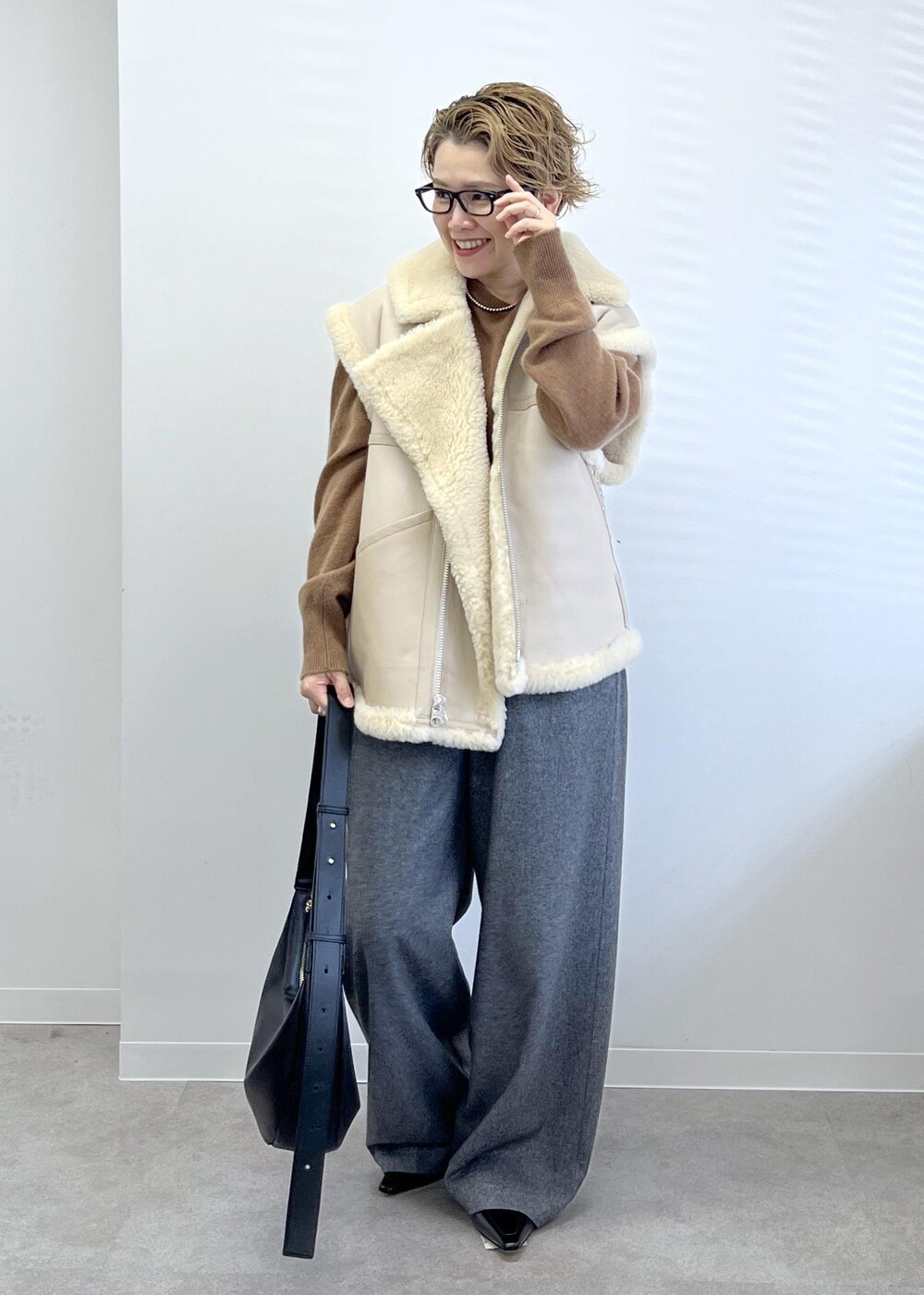 ブラック系のショルダーバッグ、グレー系のその他パンツ、ブラウン系のニット/セーターを着用したレディースの秋コーディネートの3枚目の写真