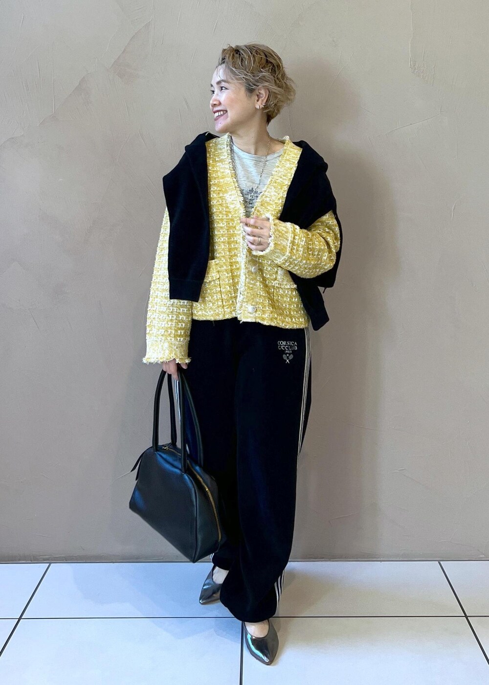 イエロー系のカーディガン/ボレロ、ブラック系のカーディガン/ボレロ、グレー系のTシャツ/カットソーを着用したレディースの冬コーディネートの7枚目の写真