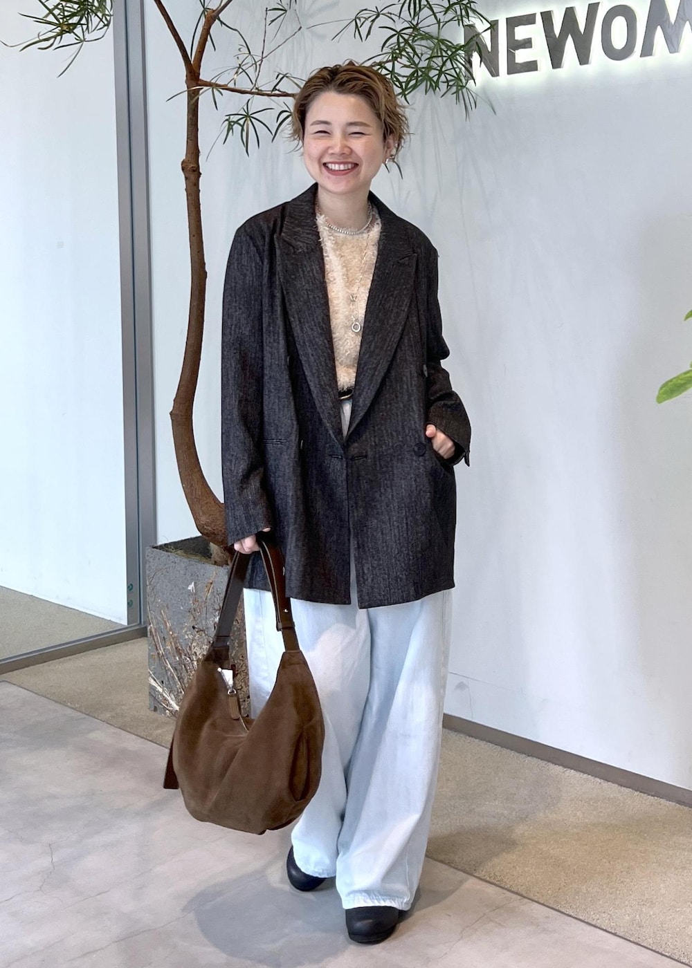 ブルー系のデニムパンツ、ベージュ系のその他トップス、ブラック系のテーラードジャケットを着用したレディースの秋コーディネートの2枚目の写真