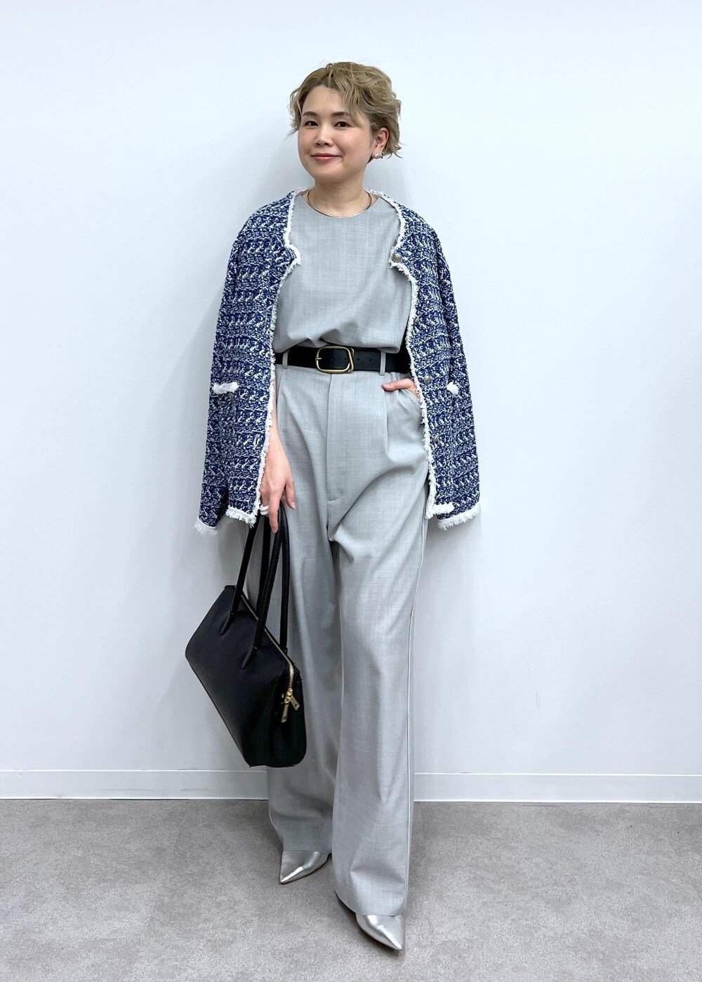 グレー系のベスト、グレー系のスラックス、シルバー系のパンプスを着用したレディースの春コーディネートの3枚目の写真
