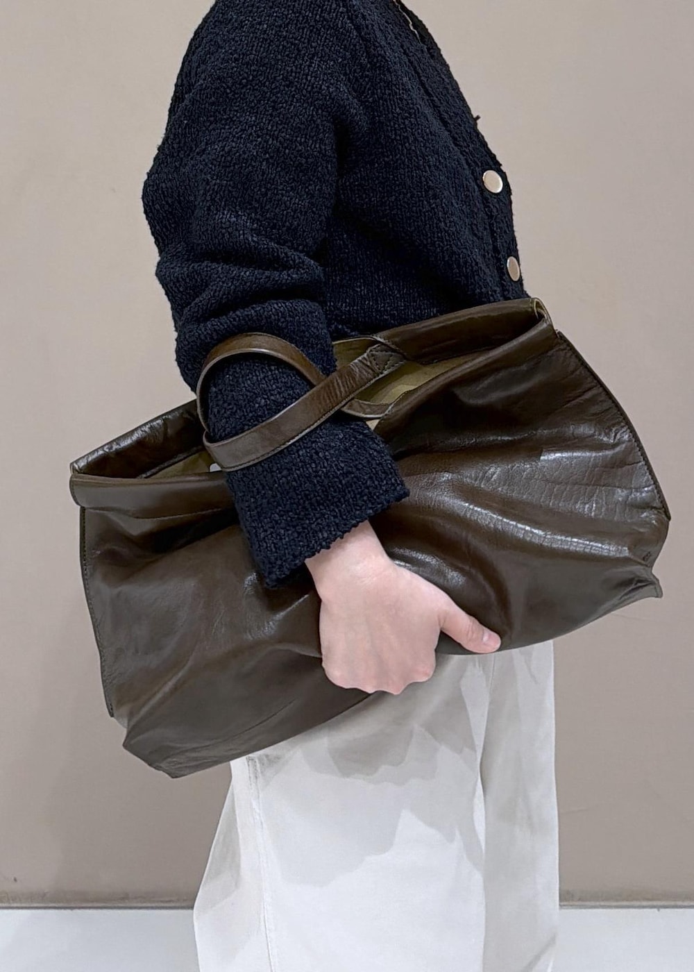 ブラック系のカーディガン/ボレロ、ホワイト系のサロペット/オーバーオール、ブラック系のローファーを着用したレディースの冬コーディネートの7枚目の写真