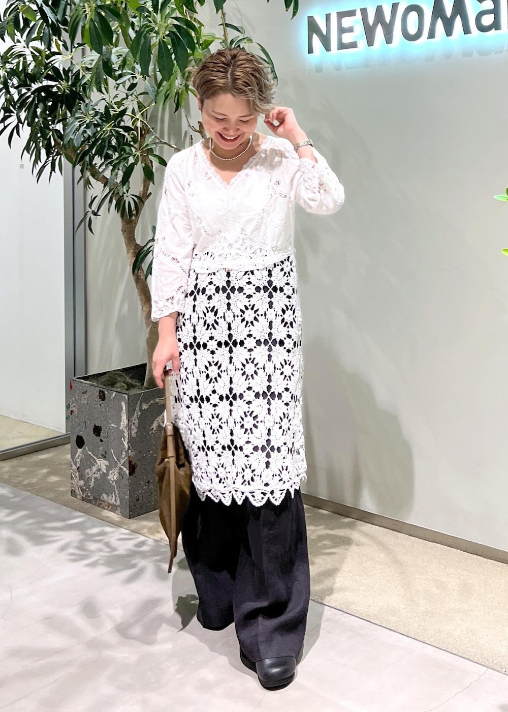 ブラック系のスラックス、ブルー系のシャツ/ブラウス、ブラウン系のショルダーバッグを着用したレディースの夏コーディネートの4枚目の写真