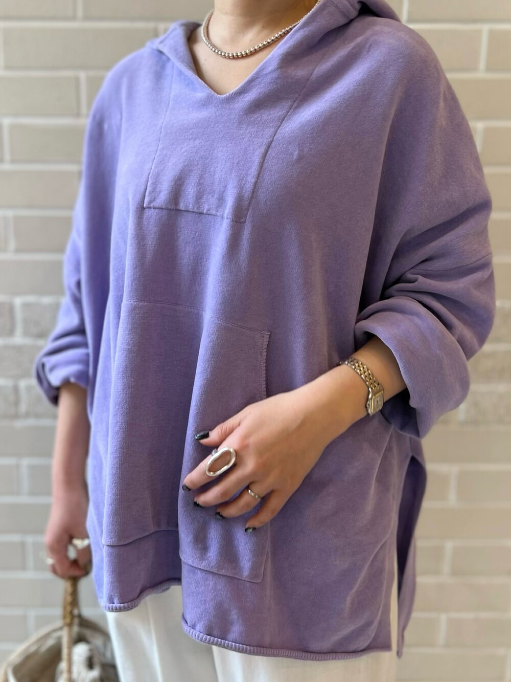 パープル系のパーカー、ホワイト系のその他パンツ、ベージュ系のかごバッグを着用したレディースの春コーディネートの4枚目の写真