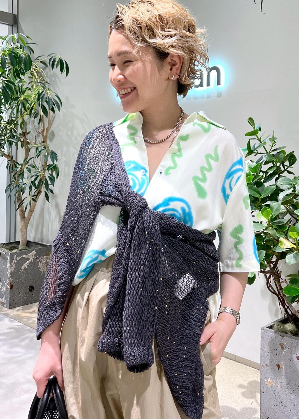 ブラック系のトートバッグ、ブラック系のサンダル、グレー系のカーディガン/ボレロを着用したレディースの春コーディネートの4枚目の写真