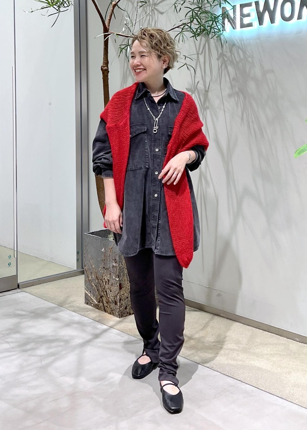 グレー系のシャツ/ブラウス、ブラック系のパンプス、レッド系のニット/セーターを着用したレディースの秋コーディネートの2枚目の写真