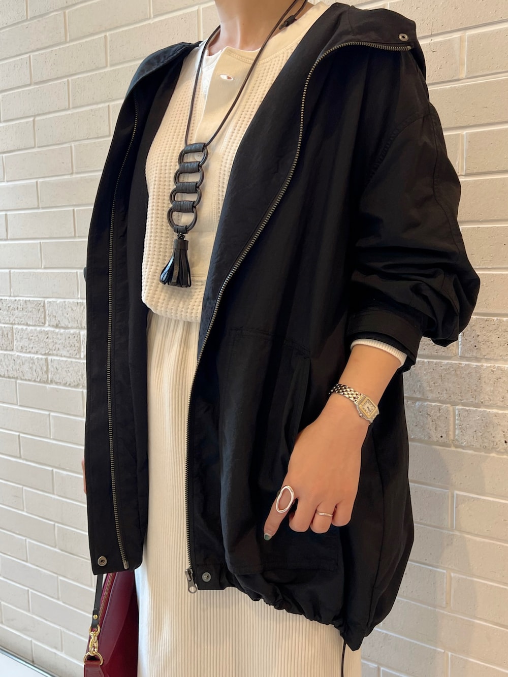 ホワイト系のTシャツ/カットソー、ブラック系のマウンテンパーカー、ホワイト系のスカートを着用したレディースの秋コーディネートの4枚目の写真