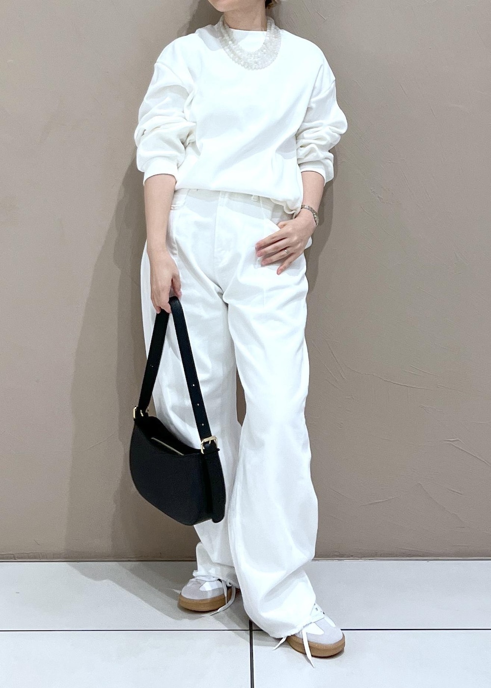 ホワイト系のデニムパンツ、ブラック系のショルダーバッグを着用したレディースの夏コーディネートの3枚目の写真