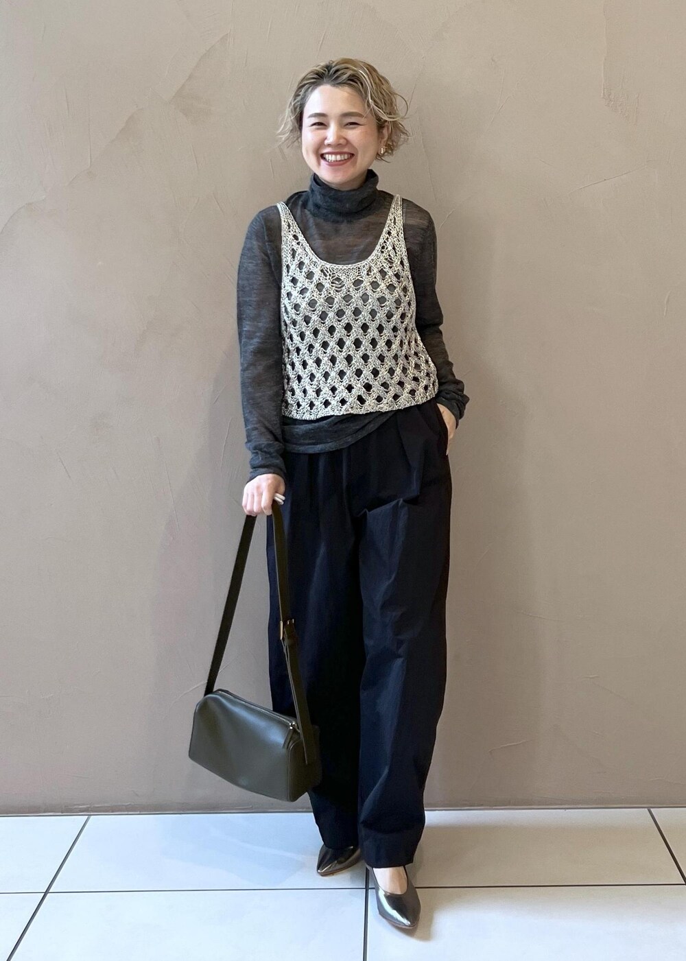 シルバー系のベスト、グレー系のニット/セーター、ブラック系のその他パンツを着用したレディースの秋コーディネートの2枚目の写真
