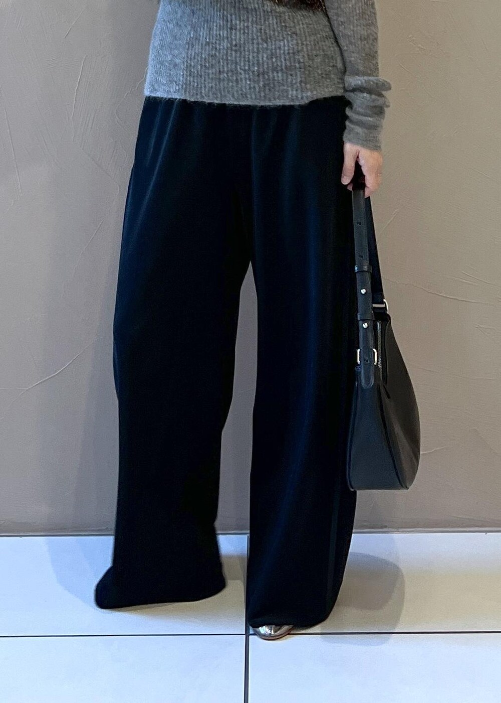 ブラック系のベスト、グレー系のニット/セーター、ブラック系のステンカラーコートを着用したレディースの冬コーディネートの10枚目の写真