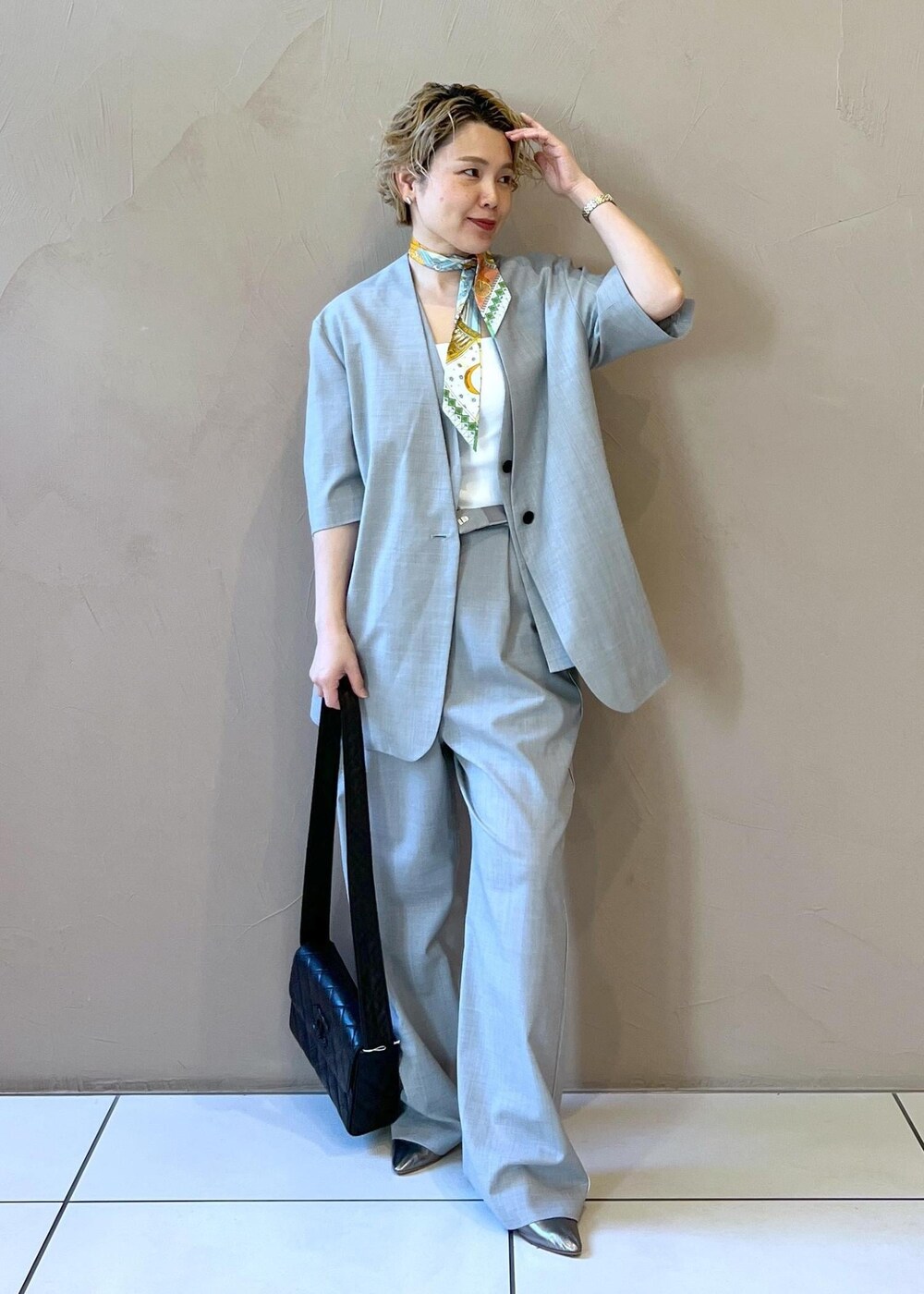 グレー系のベスト、グレー系のスラックス、グレー系のテーラードジャケットを着用したレディースの冬コーディネートの3枚目の写真