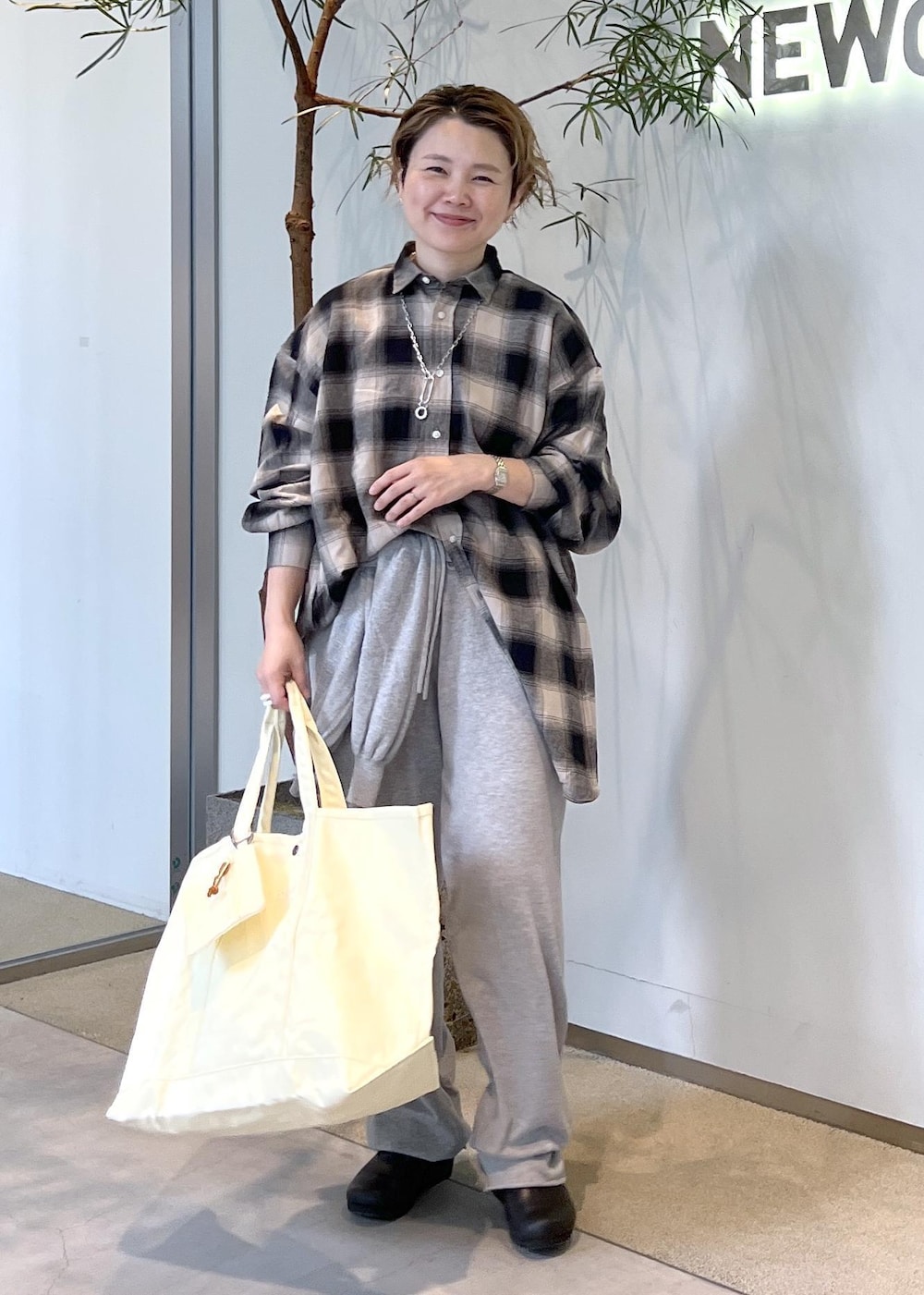 ブラック系のスニーカー、イエロー系のトートバッグを着用したレディースの秋コーディネートの2枚目の写真