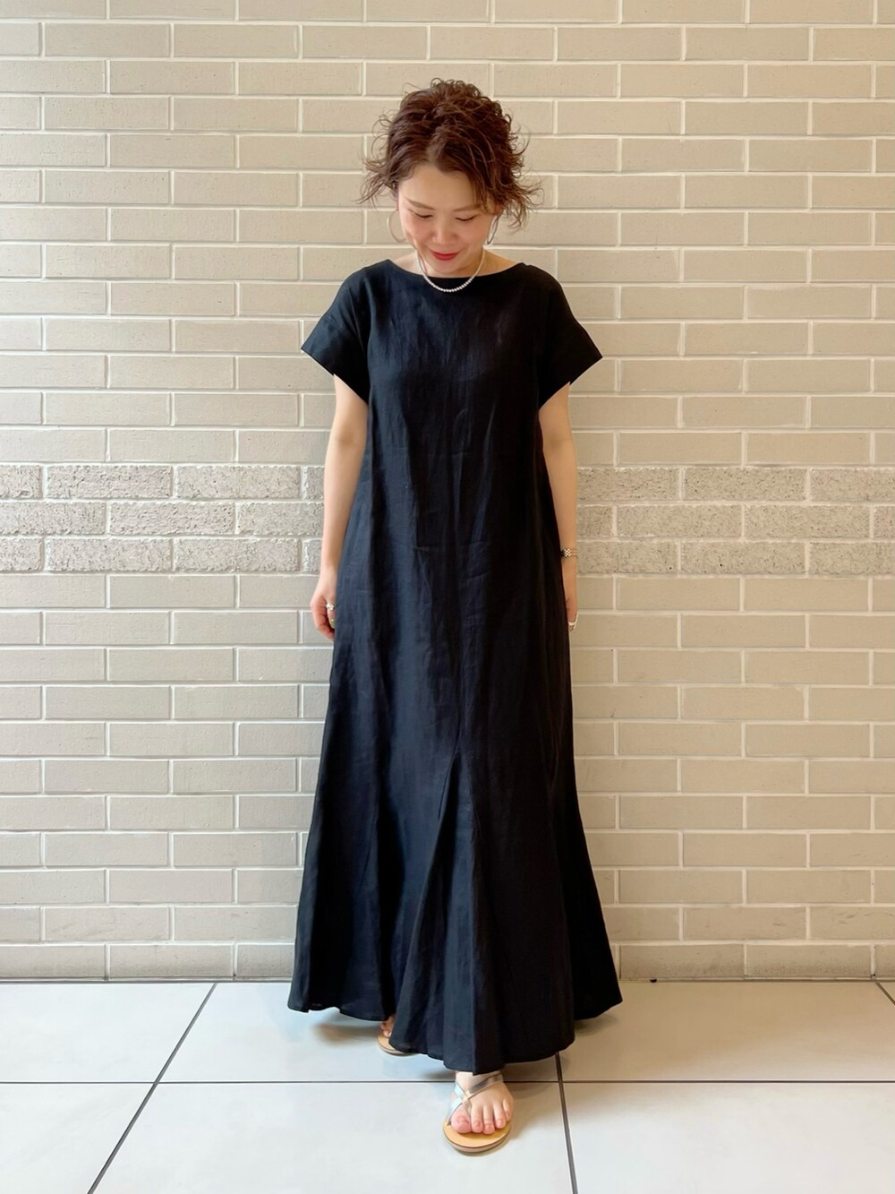 オレンジ系のシャツ/ブラウス、ブラック系のワンピース、シルバー系のサンダルを着用したレディースの夏コーディネートの5枚目の写真