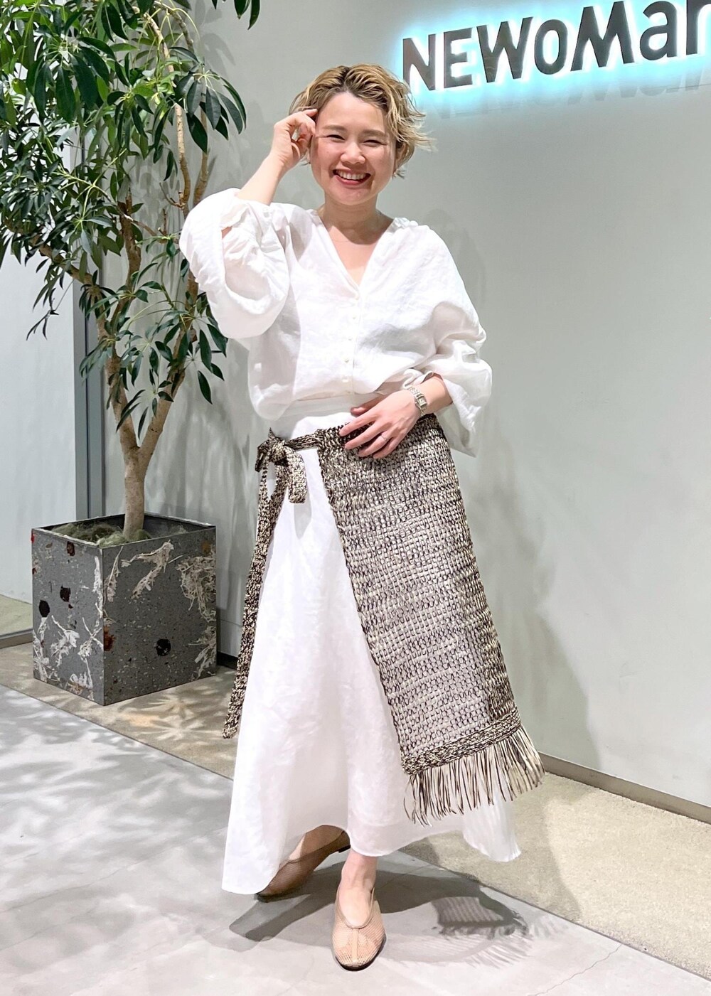 ベージュ系のパンプス、ホワイト系のスカート、ホワイト系のシャツ/ブラウスを着用したレディースの春コーディネートの2枚目の写真