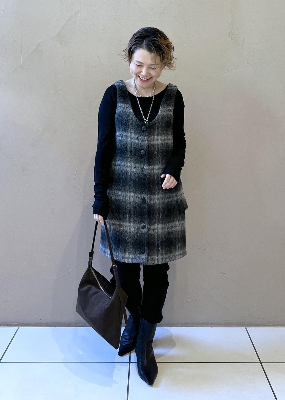 グレー系のジャンパースカート、ブラウン系のショルダーバッグ、ブラック系のTシャツ/カットソーを着用したレディースの秋コーディネートの5枚目の写真