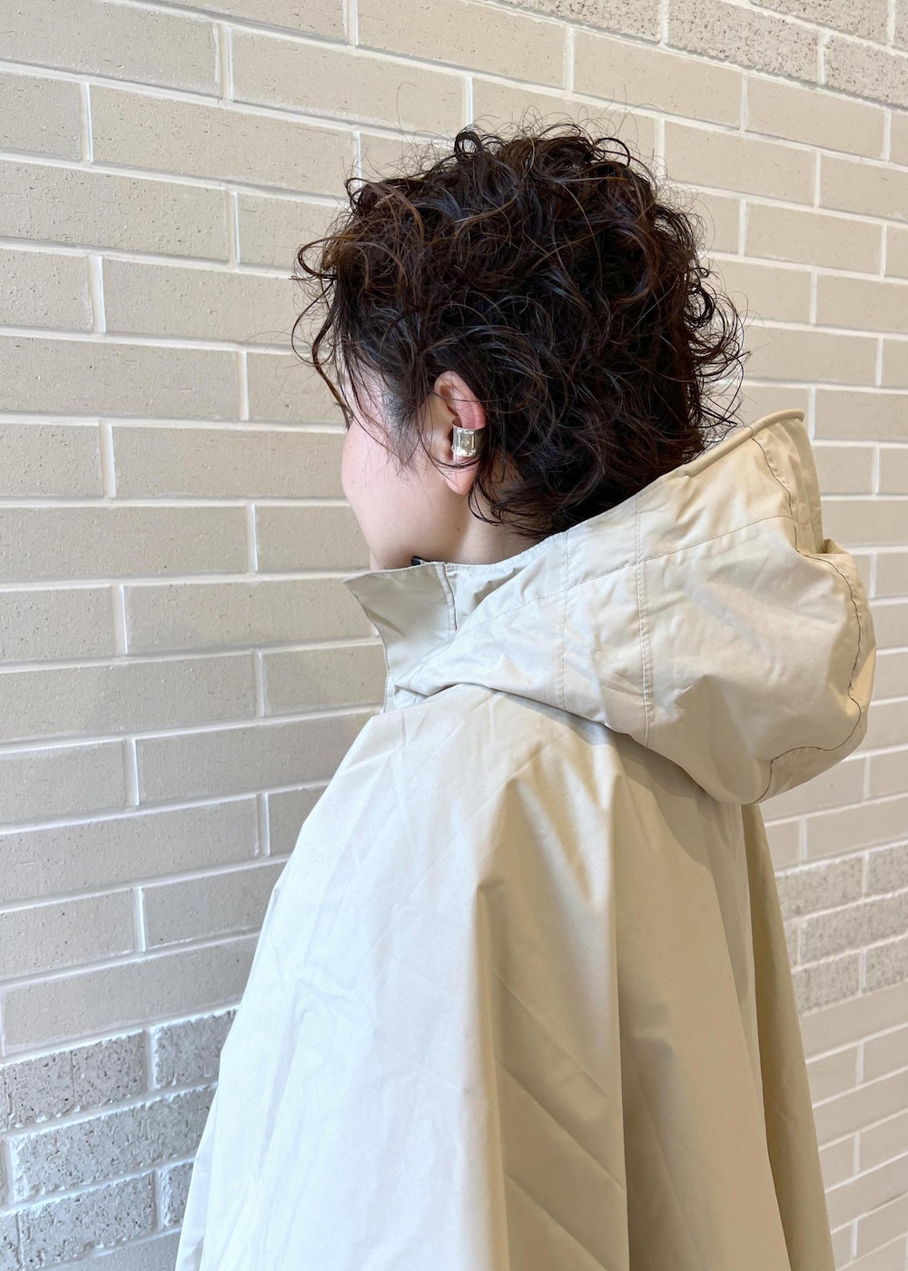 ベージュ系のトートバッグ、ブラック系のつなぎ/オールインワン、ベージュ系のレインコート/ポンチョを着用したレディースの夏コーディネートの7枚目の写真