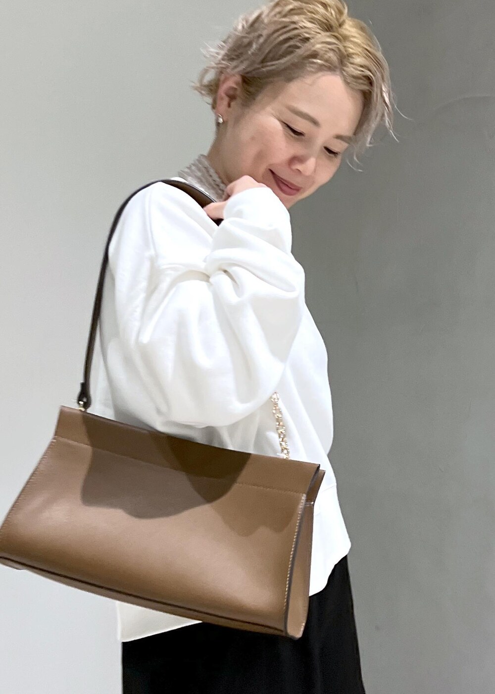 ホワイト系のスウェット、ブラック系のカーゴパンツ、ブラウン系のショルダーバッグを着用したレディースの秋コーディネートの10枚目の写真