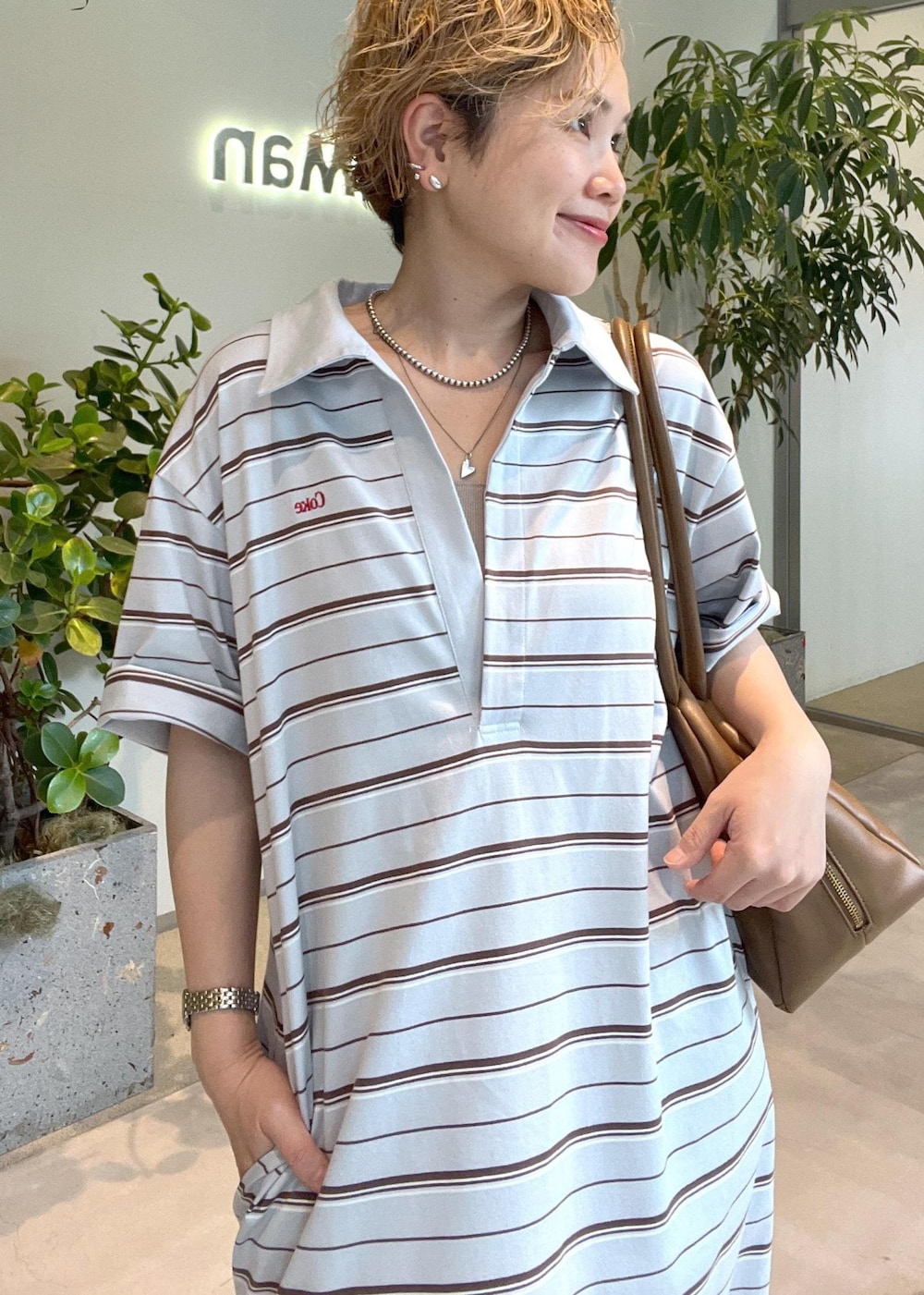 ブラウン系のボストンバッグ、ホワイト系のサンダル、ブルー系のワンピースを着用したレディースの夏コーディネートの8枚目の写真