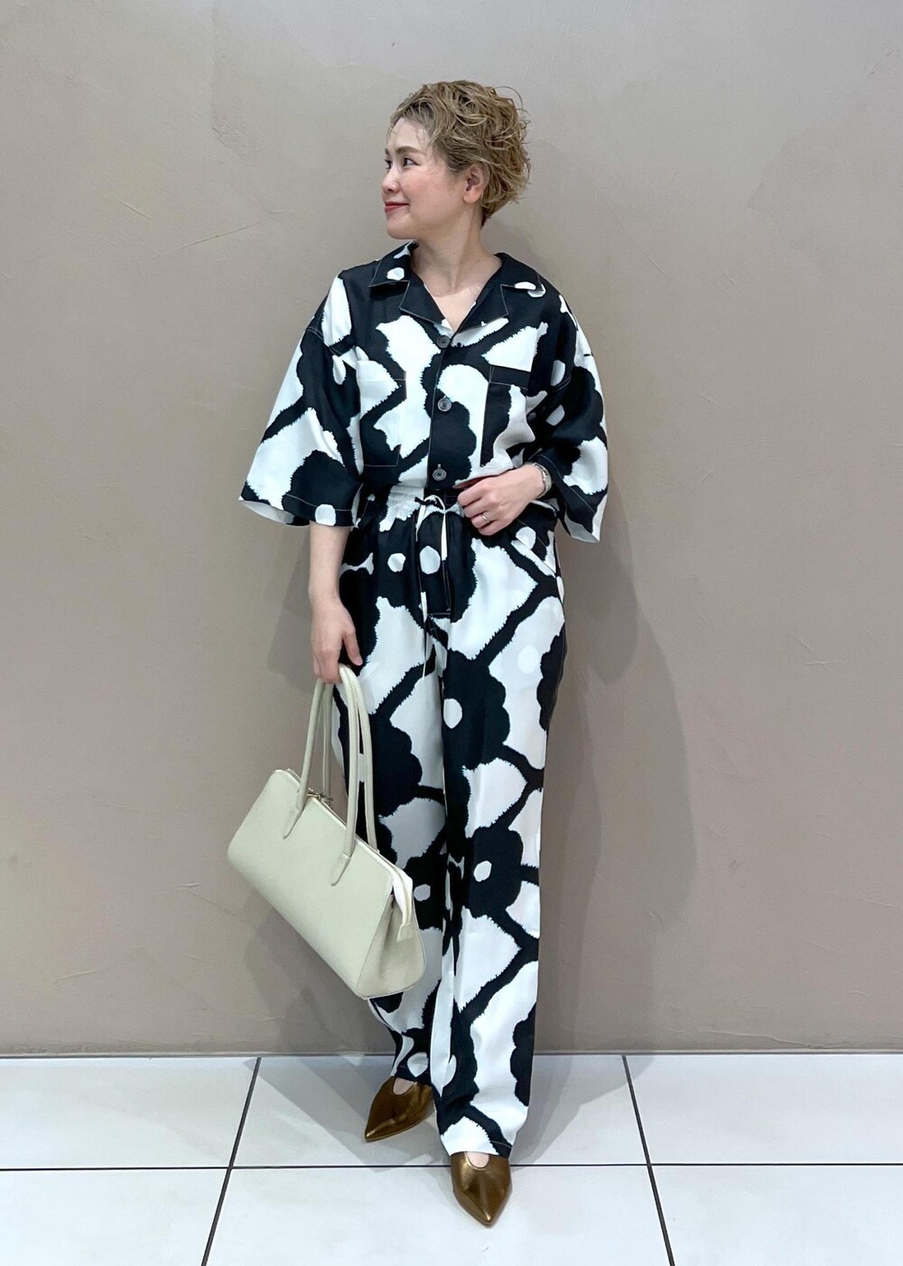 ホワイト系のボストンバッグ、その他のパンプス、ホワイト系のシャツ/ブラウスを着用したレディースの春コーディネートの2枚目の写真