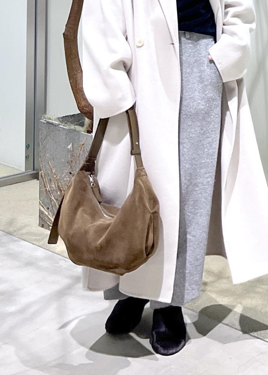 ホワイト系のチェスターコート、ブラック系のスウェット、ブラウン系のショルダーバッグを着用したレディースの秋コーディネートの10枚目の写真