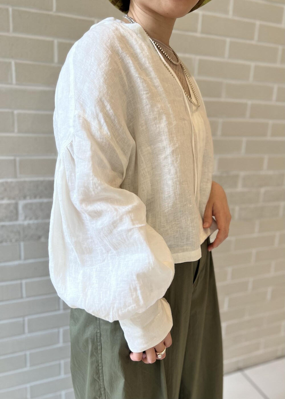 ホワイト系のサンダル、ベージュ系のTシャツ/カットソー、ホワイト系のシャツ/ブラウスを着用したレディースの春コーディネートの5枚目の写真