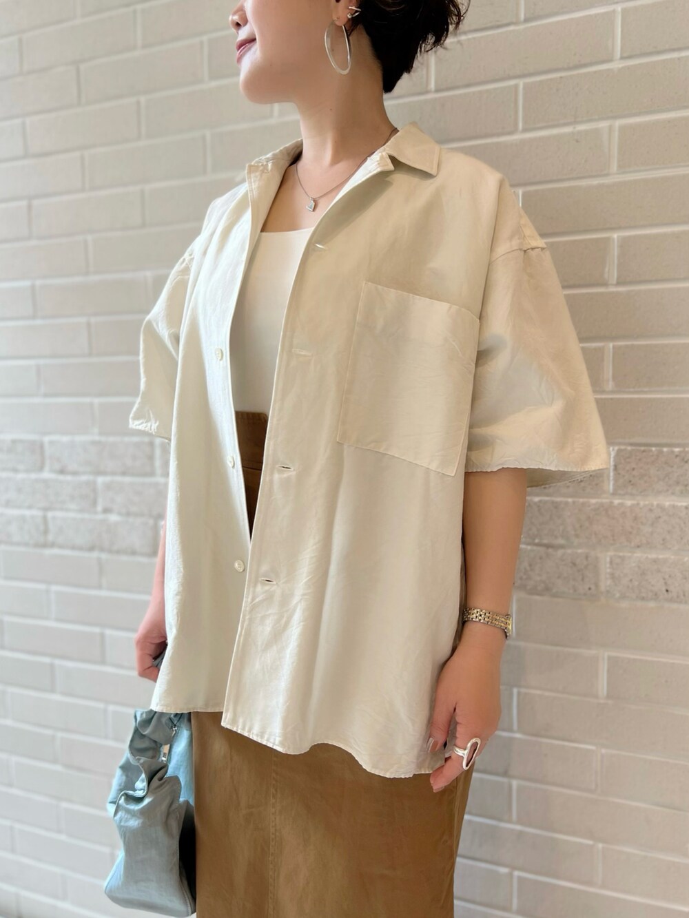 ホワイト系のシャツ/ブラウス、ホワイト系のキャミソール、イエロー系のスカートを着用したレディースの夏コーディネートの4枚目の写真