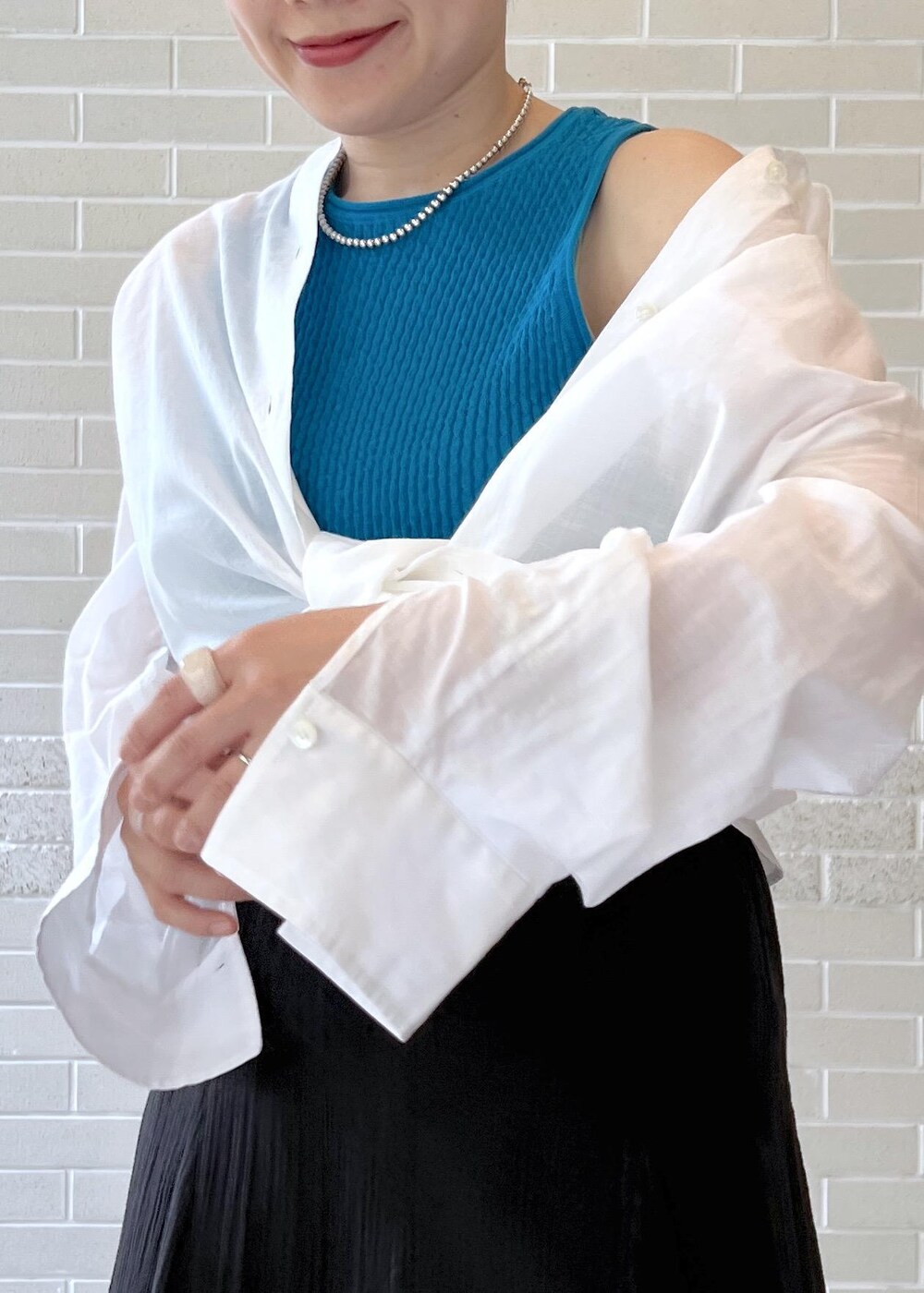 ブラック系のスカート、ホワイト系のシャツ/ブラウス、ブルー系のタンクトップを着用したレディースの夏コーディネートの7枚目の写真