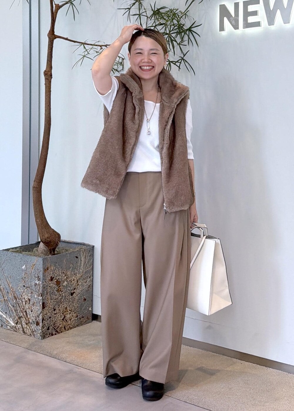 ホワイト系のTシャツ/カットソー、ベージュ系のその他パンツ、ブラウン系のベストを着用したレディースの秋コーディネートの2枚目の写真