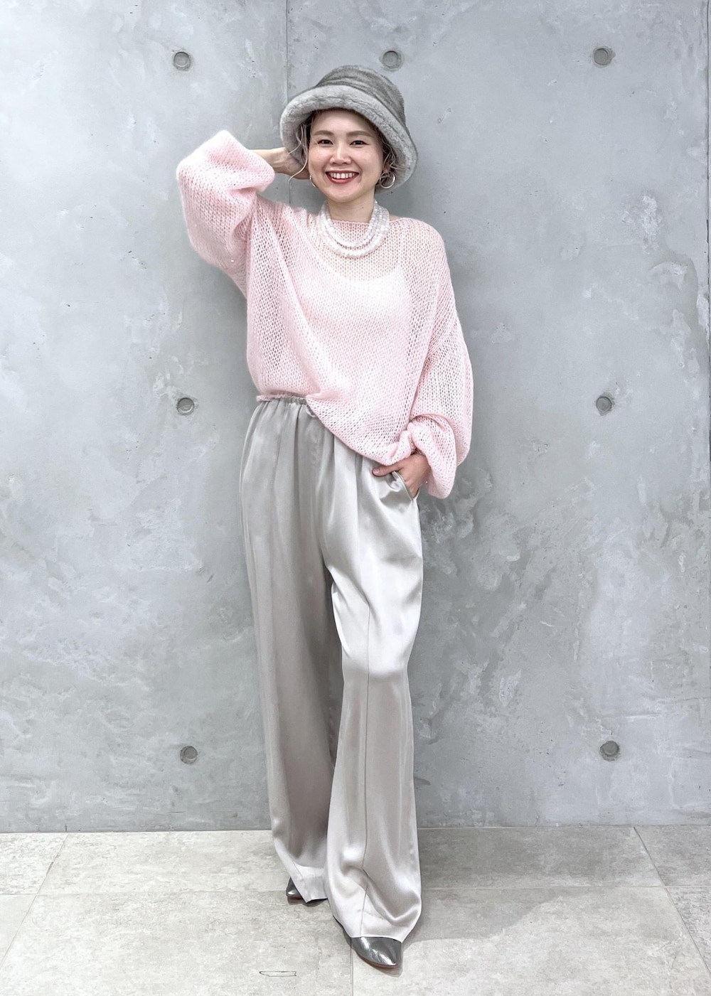 グレー系のその他パンツ、ピンク系のニット/セーター、シルバー系のパンプスを着用したレディースの夏コーディネートの2枚目の写真