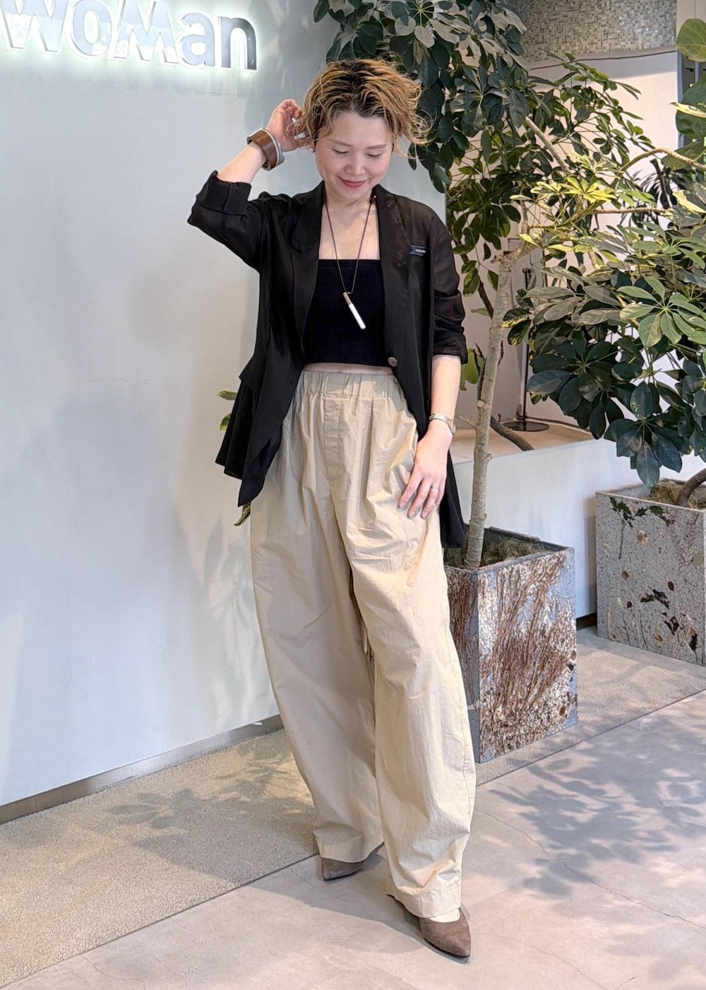 ベージュ系のその他パンツ、ブラック系のテーラードジャケットを着用したレディースの春コーディネートの2枚目の写真