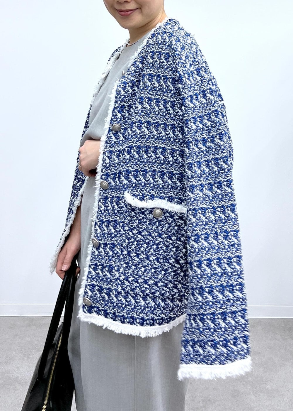 グレー系のベスト、グレー系のスラックス、シルバー系のパンプスを着用したレディースの春コーディネートの7枚目の写真