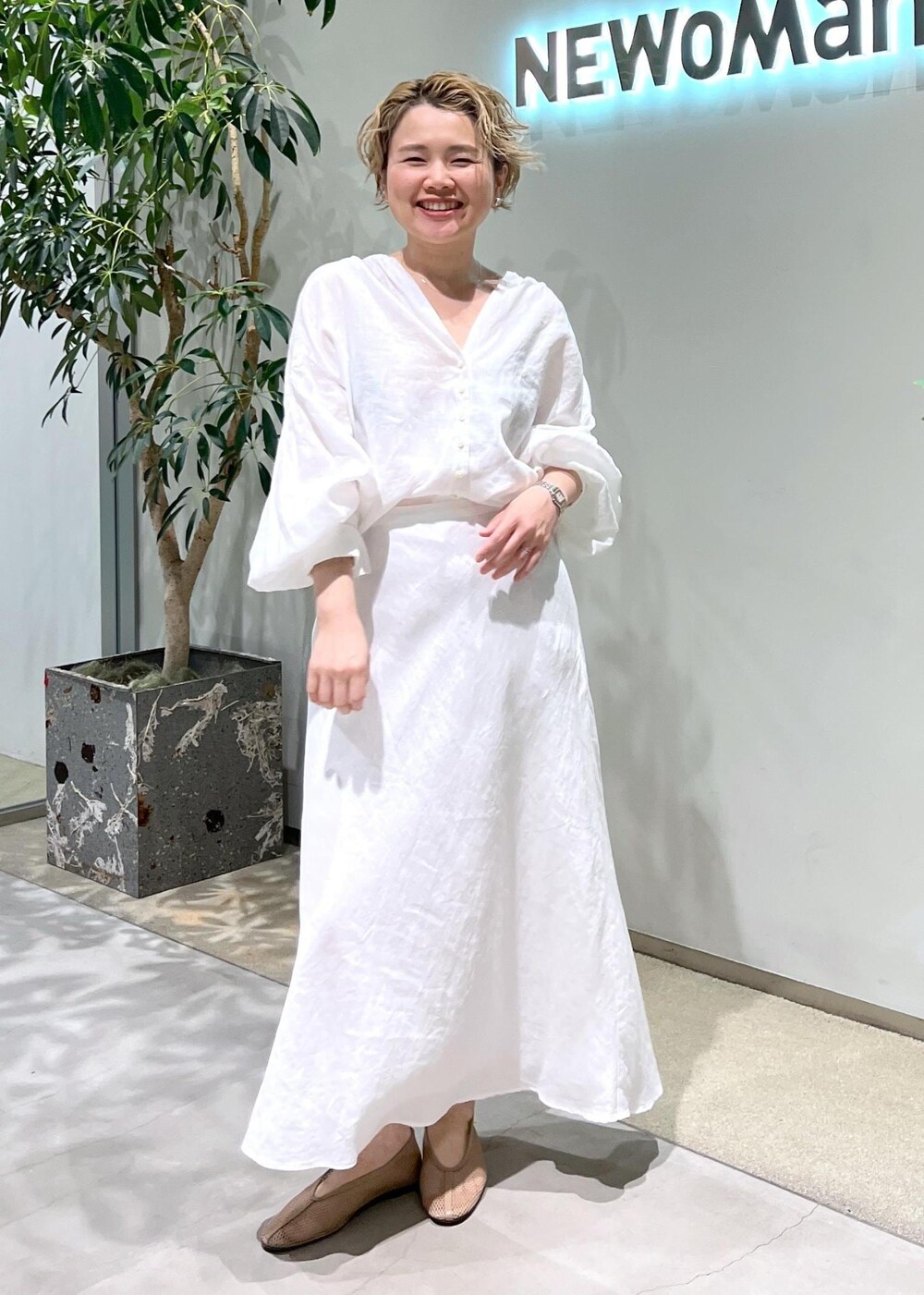 ベージュ系のパンプス、ホワイト系のスカート、ホワイト系のシャツ/ブラウスを着用したレディースの春コーディネートの6枚目の写真