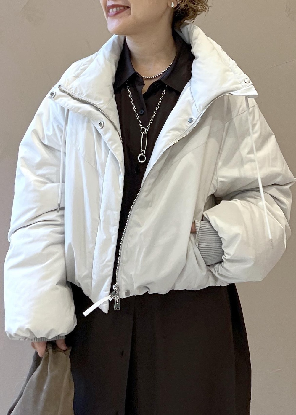 ホワイト系のダウンジャケット/コート、グレー系のハンドバッグ、グレー系のワンピースを着用したレディースの秋コーディネートの9枚目の写真