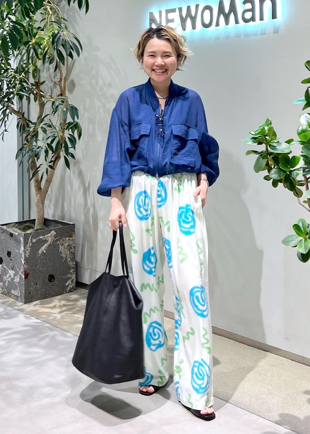 ブラック系のサンダル、ブルー系のブルゾン、ブラック系のサングラスを着用したレディースの春コーディネートの5枚目の写真