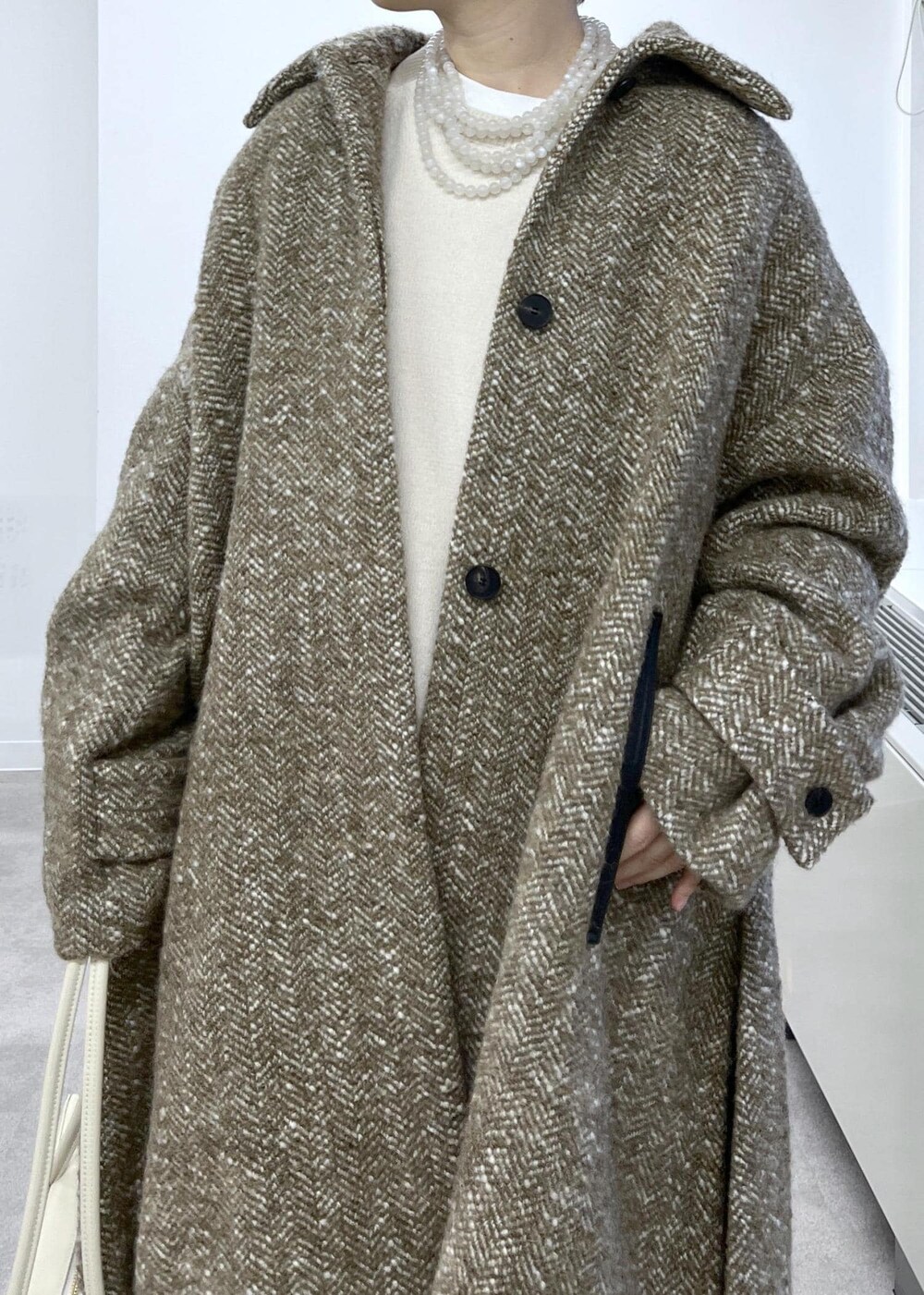 ホワイト系のスウェット、ベージュ系のステンカラーコート、ブラウン系のその他パンツを着用したレディースの秋コーディネートの5枚目の写真