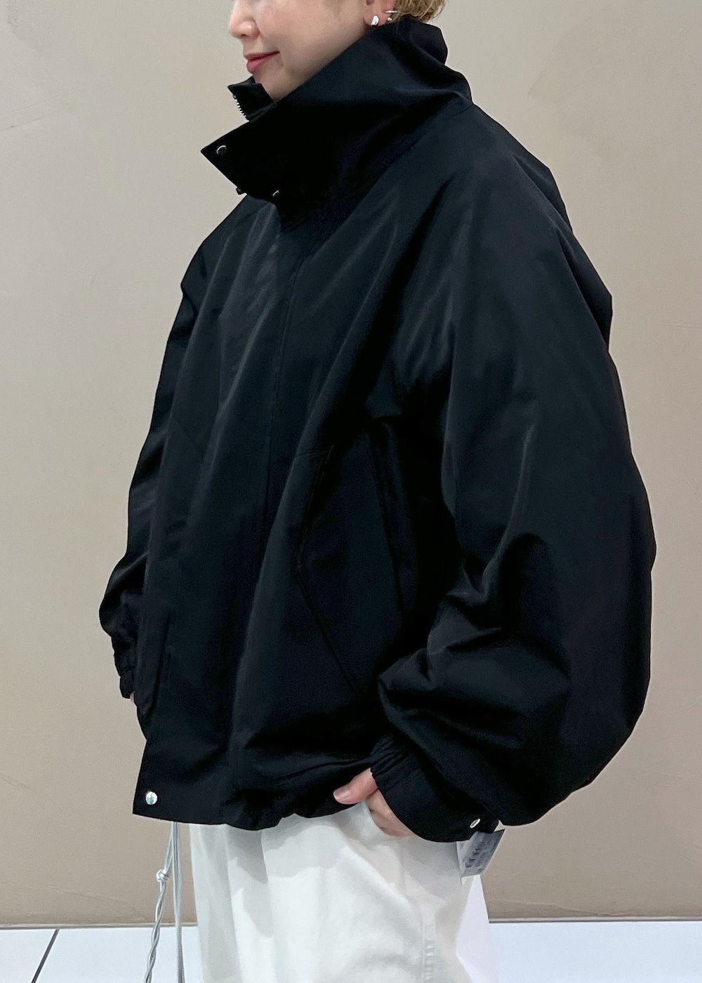 ブラック系のブルゾン、ホワイト系のその他パンツ、シルバー系のショルダーバッグを着用したレディースの春コーディネートの7枚目の写真