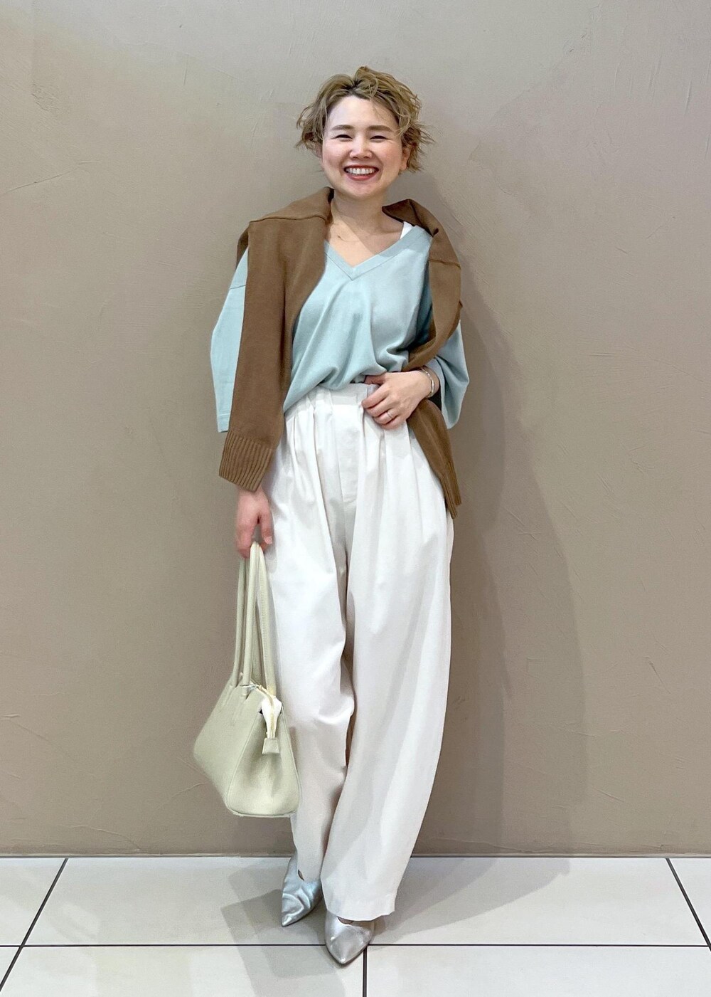 ホワイト系のボストンバッグ、イエロー系のカーディガン/ボレロ、ホワイト系のその他パンツを着用したレディースの春コーディネートの4枚目の写真