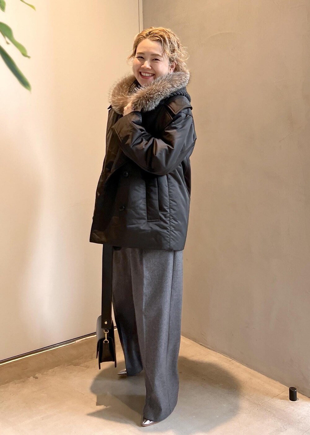 ブラック系のショルダーバッグ、グレー系のニット/セーター、グレー系のスラックスを着用したレディースの秋コーディネートの5枚目の写真