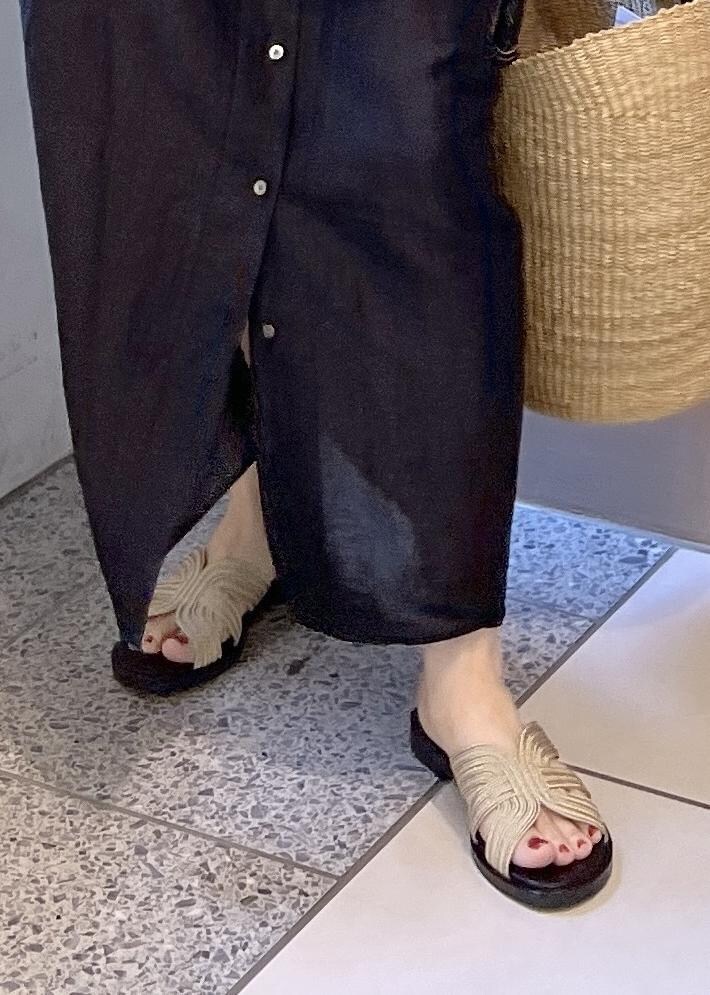 ゴールド系のサンダル、ブラック系のワンピース、ベージュ系のかごバッグを着用したレディースの夏コーディネートの9枚目の写真