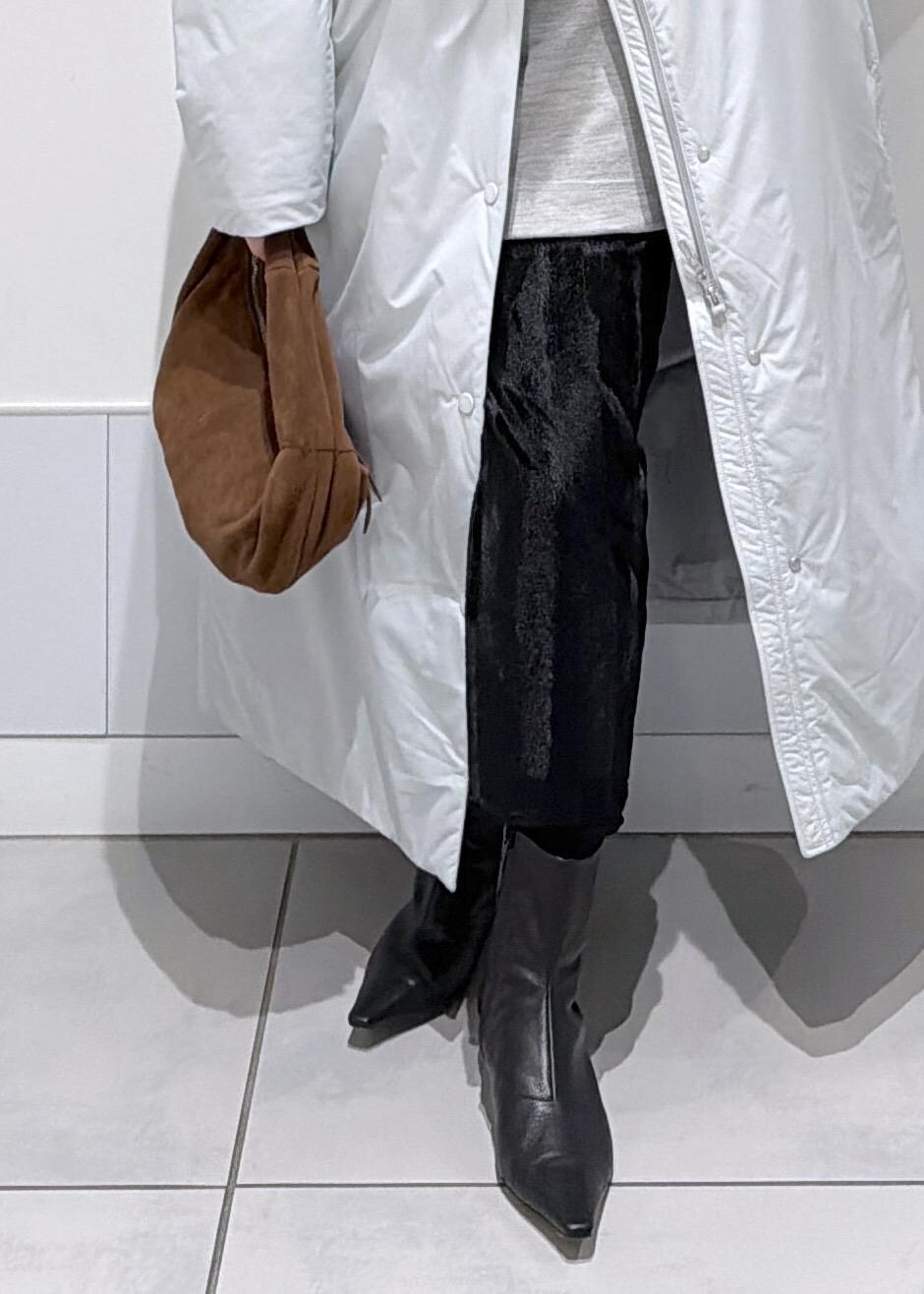 ブラック系のスカート、ブラウン系のハンドバッグ、グレー系のダウンジャケット/コートを着用したレディースの秋コーディネートの7枚目の写真