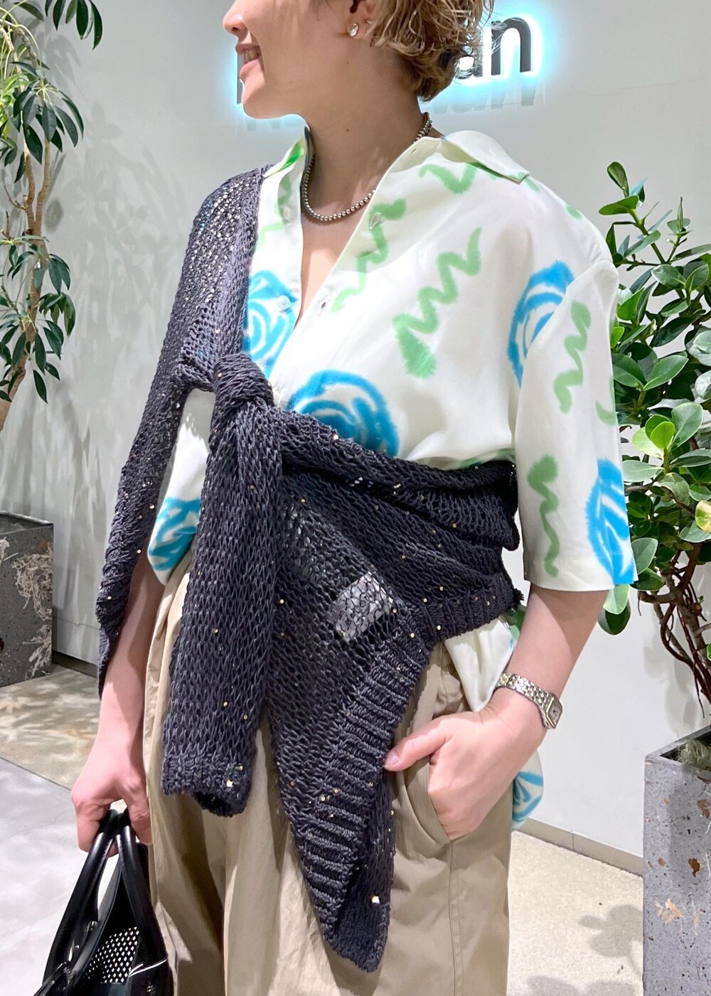 ブラック系のトートバッグ、ブラック系のサンダル、グレー系のカーディガン/ボレロを着用したレディースの春コーディネートの5枚目の写真