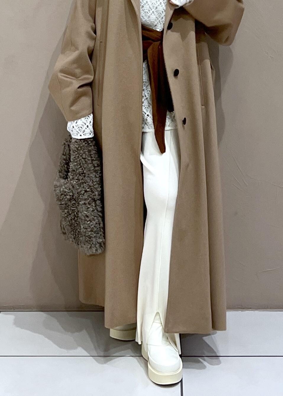 ブラウン系のハンドバッグ、ホワイト系のTシャツ/カットソー、イエロー系のステンカラーコートを着用したレディースの冬コーディネートの10枚目の写真